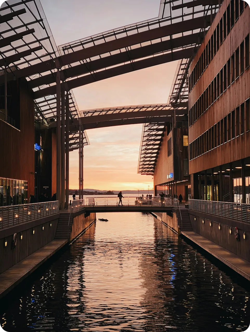 Waterfront canal in central Oslo with modern architecture at sunset