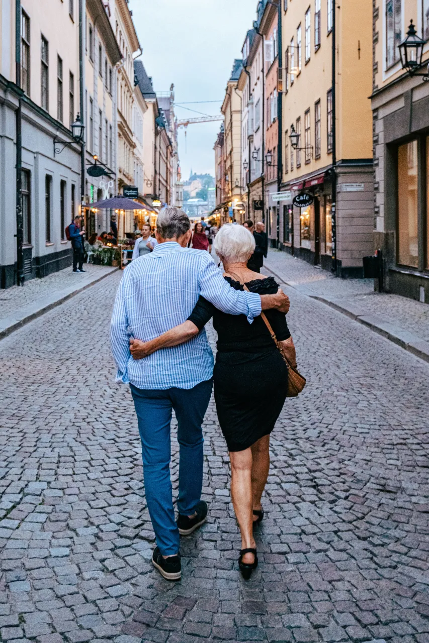 Couple walking through Gamla Stan old town in Stockholm, cobblestone street and colorful buildings