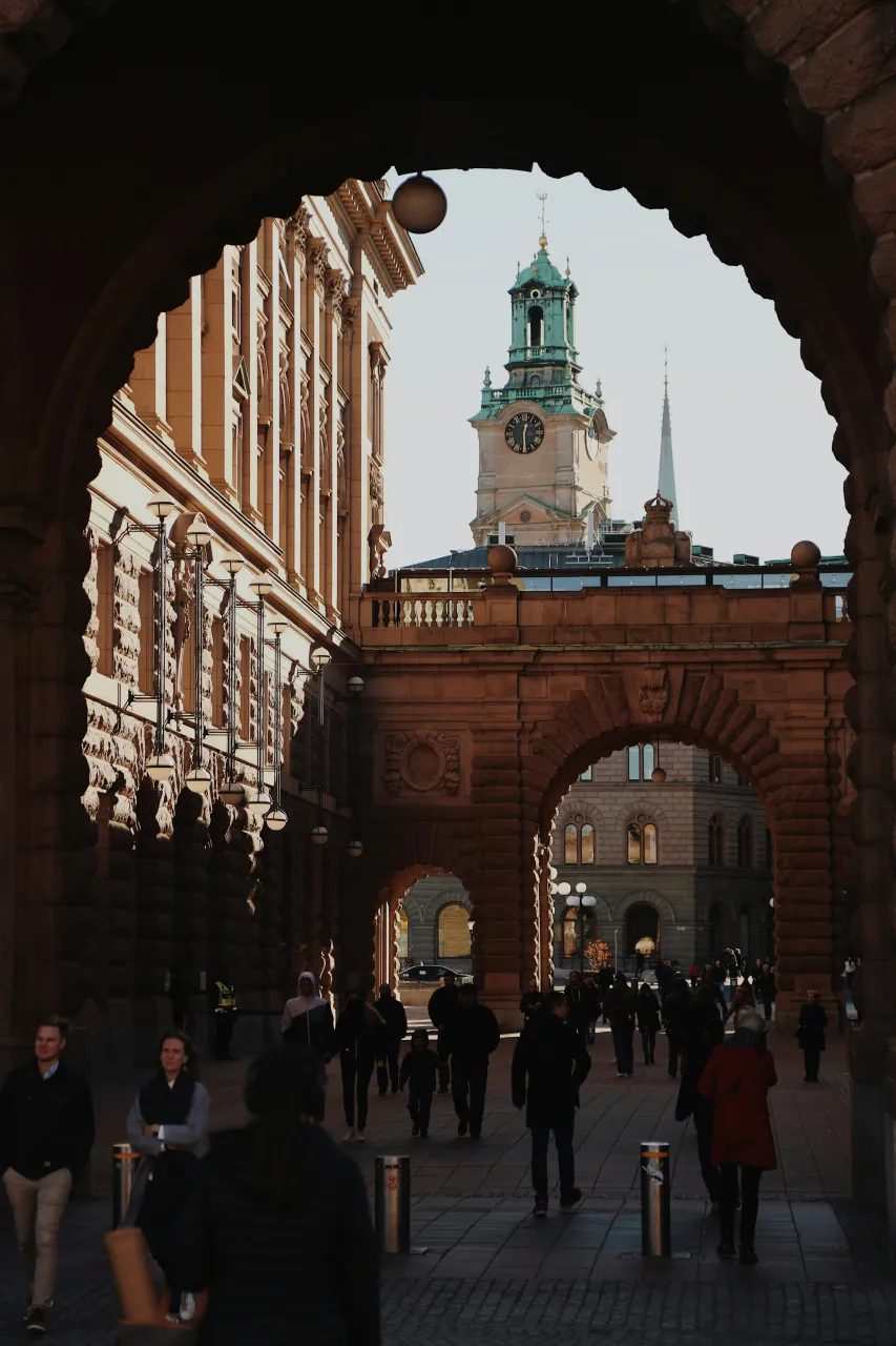 View through archway to Stortorget square in Gamla Stan Stockholm with people and historic buildings