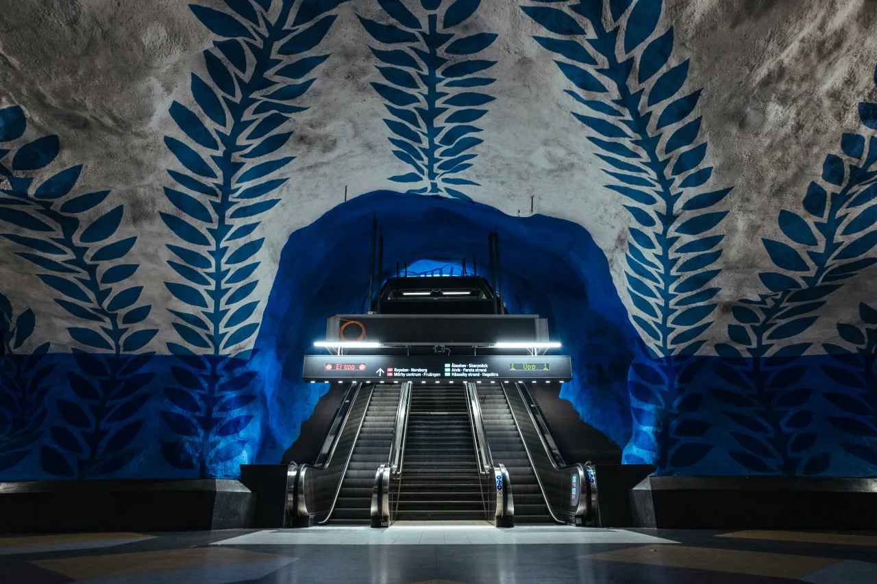Stockholm metro station with blue cave walls and artistic leaf patterns