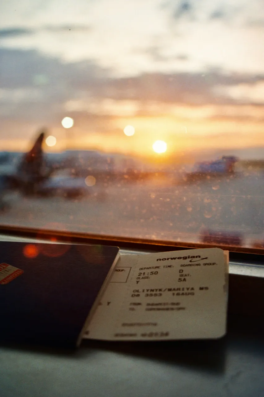 Oslo sunset view seen through a train window with travel ticket in foreground